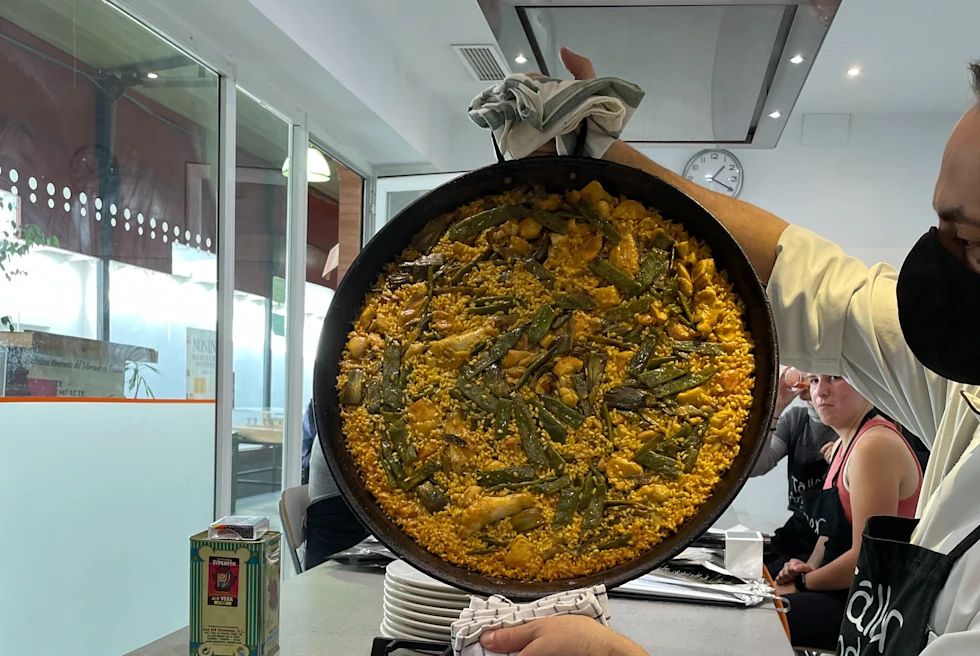 person holding up pan with food