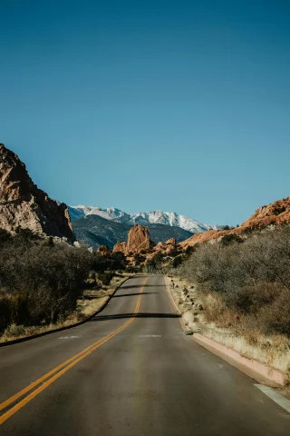 Empty road leading into a valley of mountains