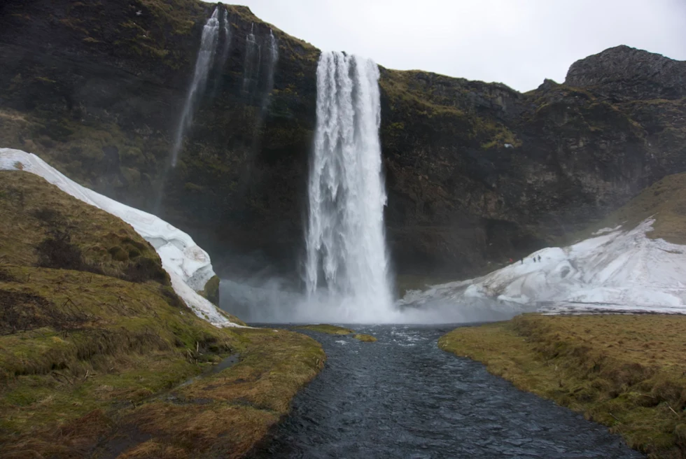 waterfall over a rock cliff on a cloudy day