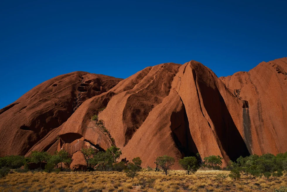 Brown rocky hills in a dessert with trees.