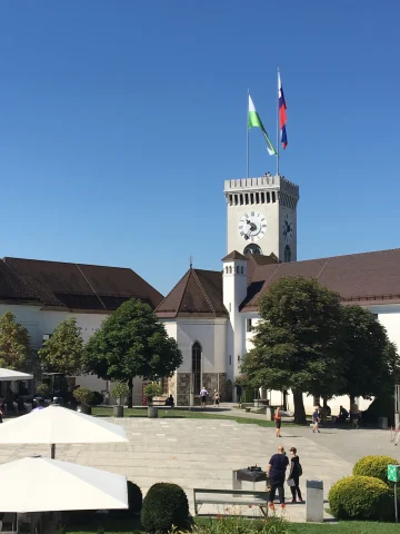 A castle with two flags on a sunny day.