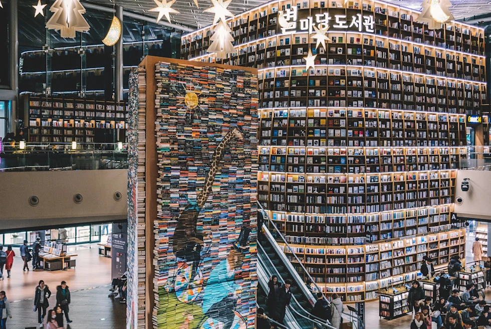 people walking inside large library with high ceilings