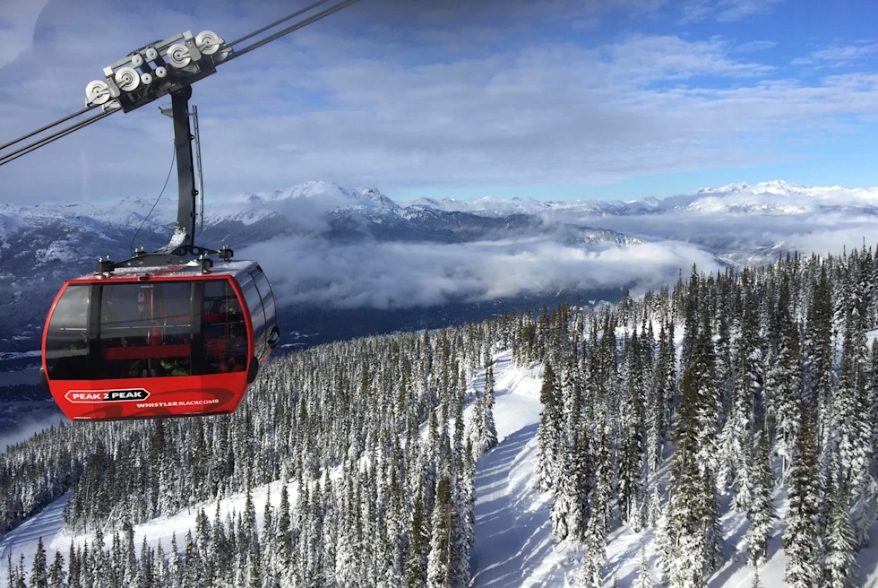 red gondola on a snowy mountain during daytime