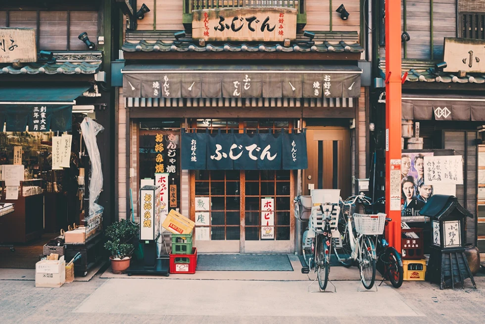 Japanese street and shops with colorful signs and characters bicycles out front