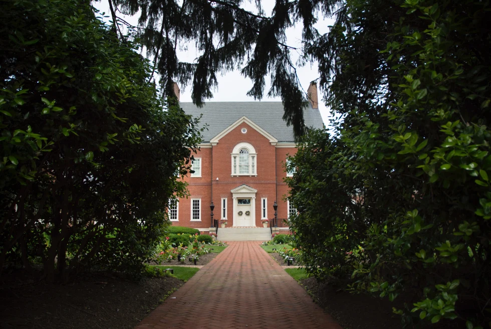 Red brick house with trees and cloudy trees