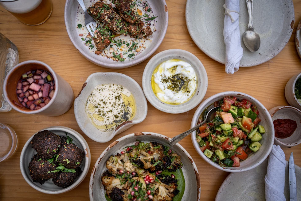 Food in white plates with silverware on wooden table