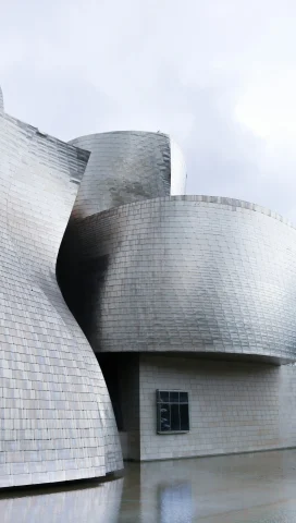 A close-up shot of the curvy architecture of the exterior of the Guggenheim Museum in Bilboa, Spain.