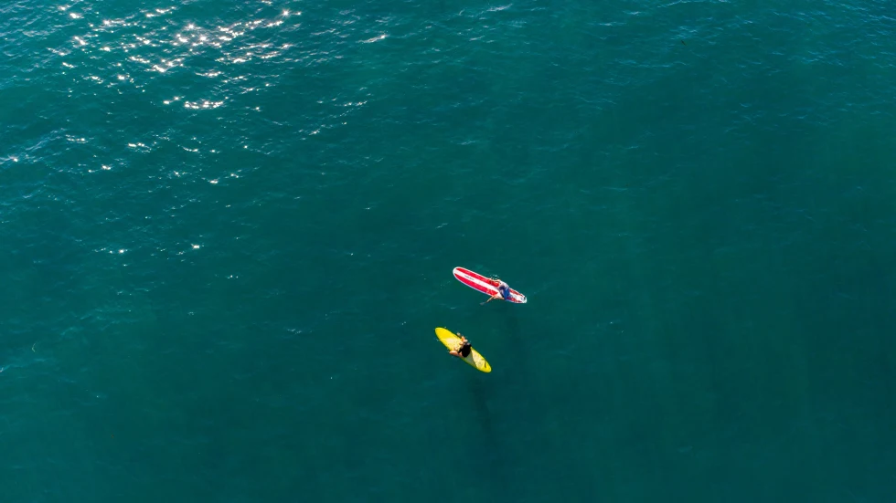 Two people on a paddle board in the ocean.