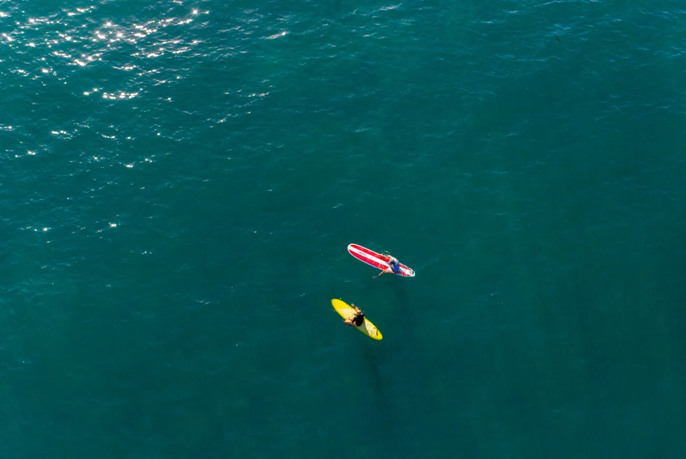 Two people on a paddle board in the ocean.