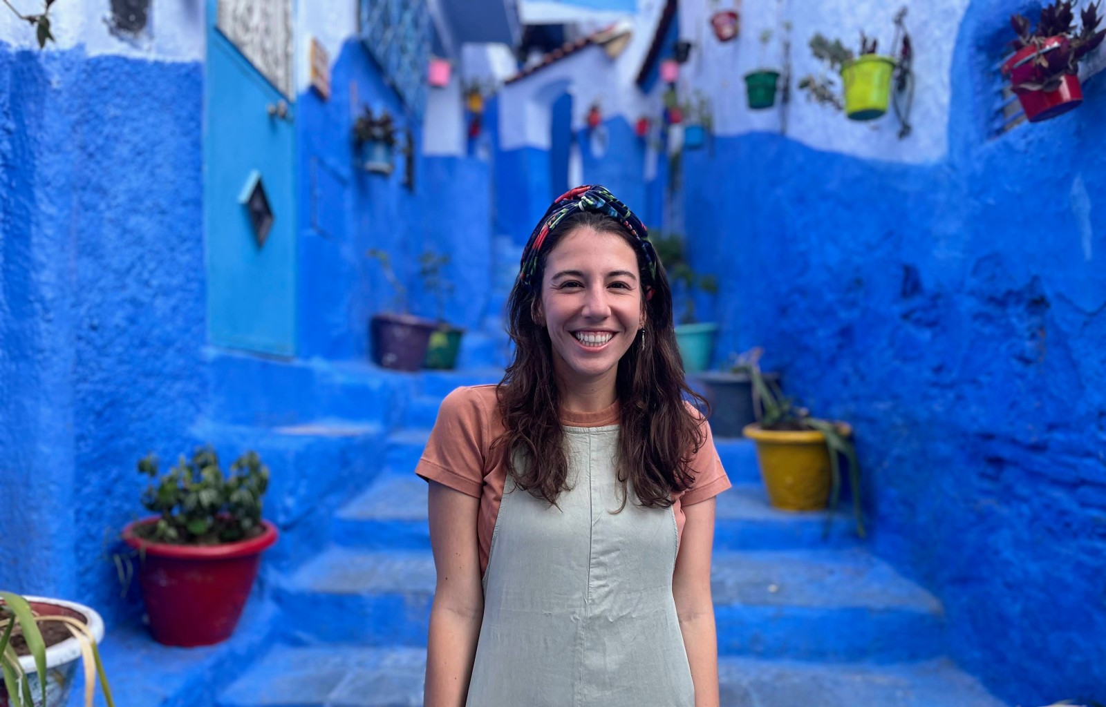 Woman standing in front of bright blue city walls