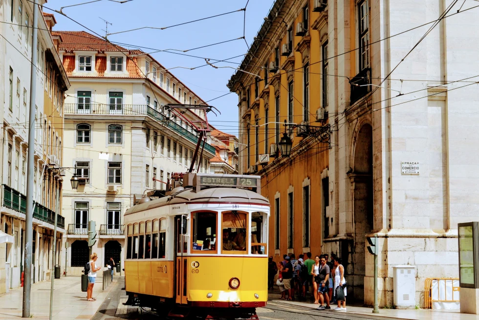 A yellow bus on a street with buildings.