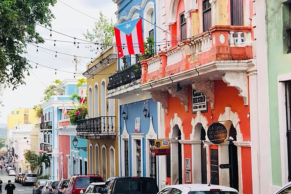 Street lined with cars and colorful buildings during daytime