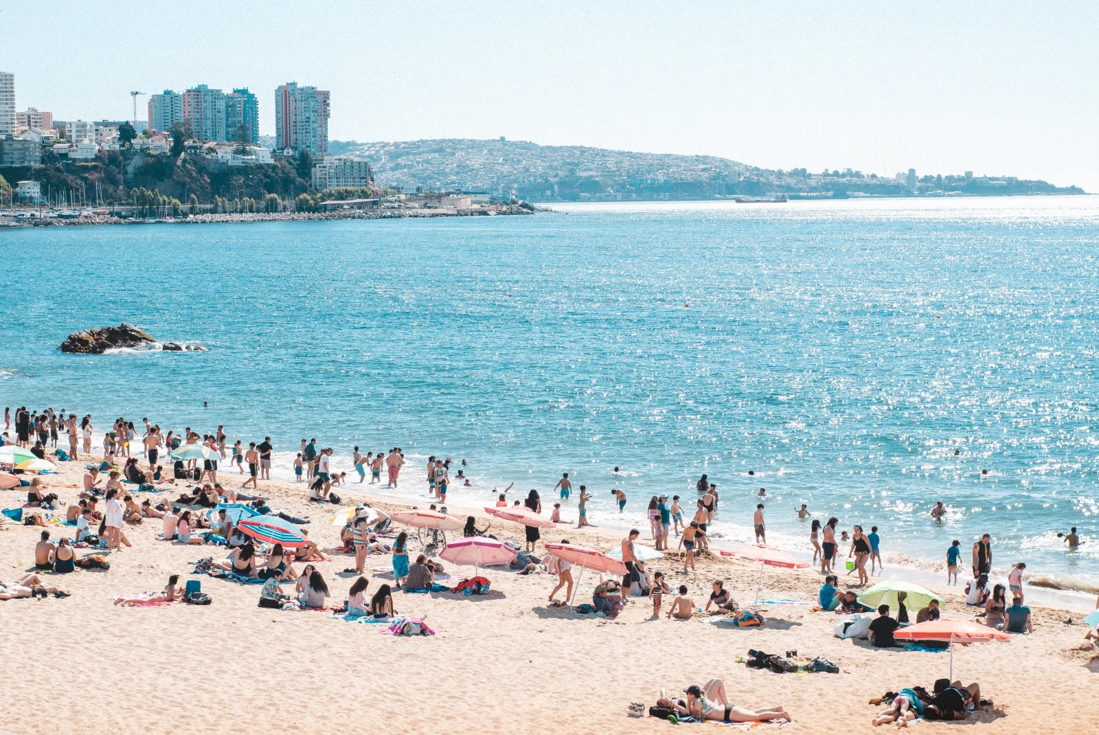 Body of water with people on the beach on sunny day during daytime
