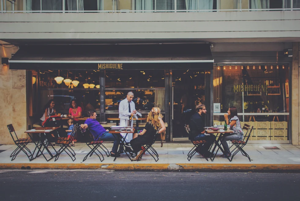 people sitting at tables outside during daytime