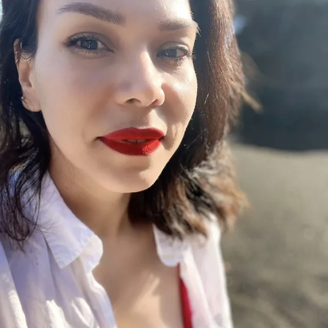 Travel Advisor Atzimba Inda Ramirez wearing a white and red shirt with red lipstick.