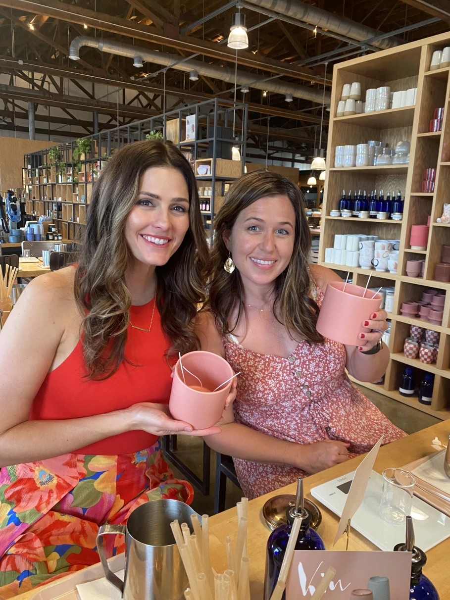 Two girls holding pink cups.