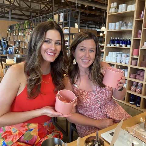 Two girls holding pink cups.