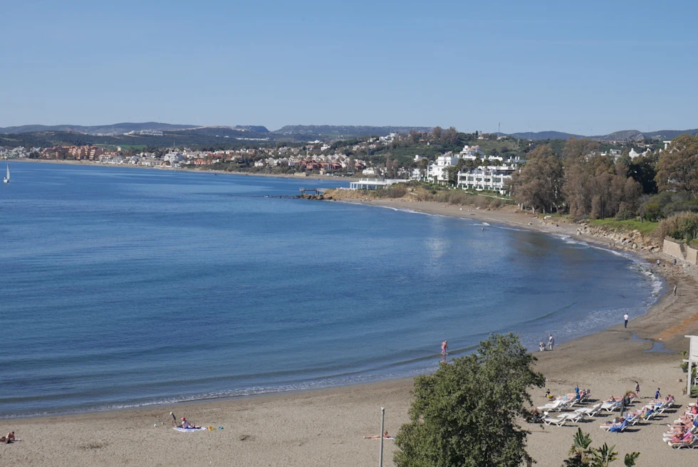 Body of water and beach with blue skies during daytime