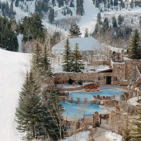 pool surrounded by snowy mountains during daytime