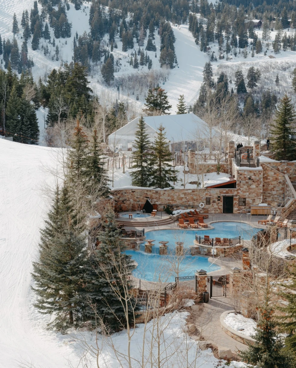 pool surrounded by snowy mountains during daytime