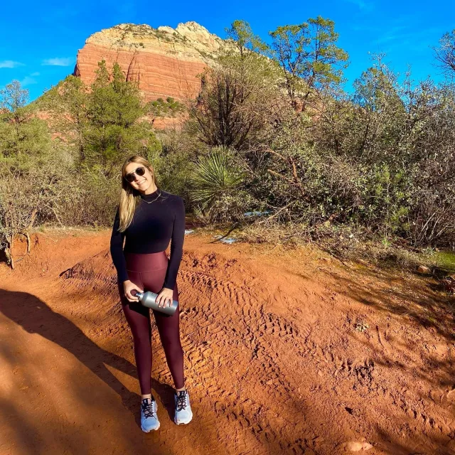 Picture of Nicole trekking in a sandy desert in front of a mountain