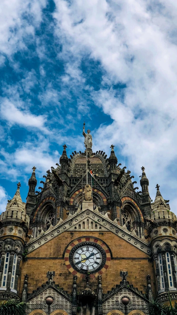 A low-angled shot of the Chhatrapati Shivaji Maharaj Terminus Railway Station in Mumbai, an elaborate exterior with a clock in the center.9
