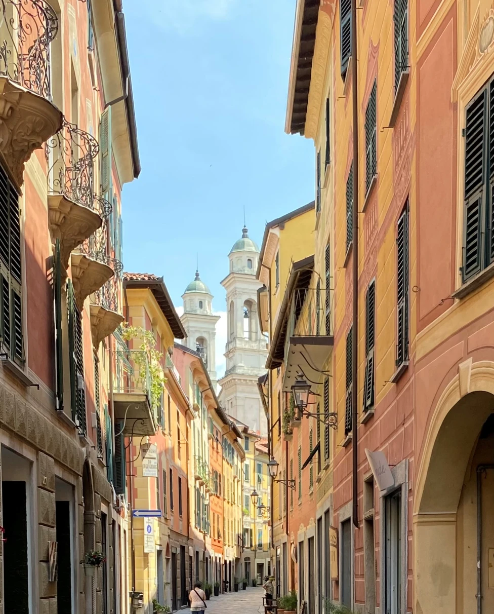 A small street with yellow and orange buildings in Italy. 
