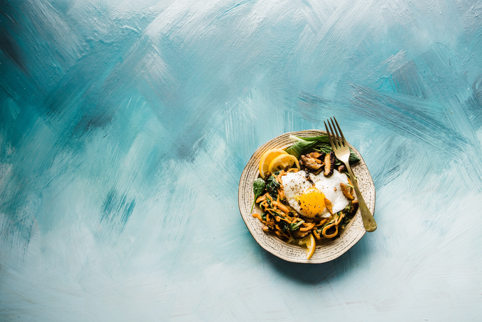 Plate of egg and greens on a blue and white table