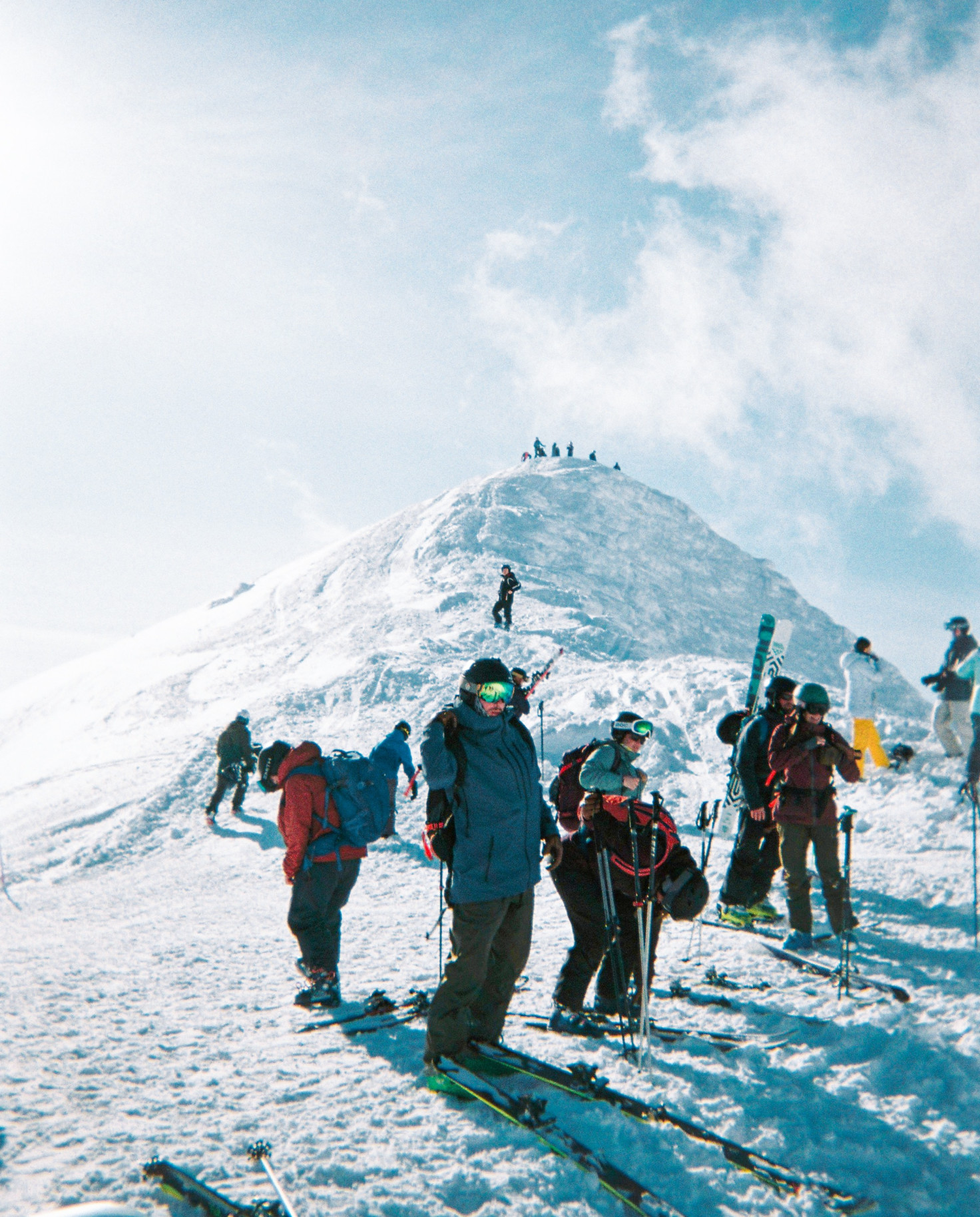 Skiers standing on top of mountain during daytime