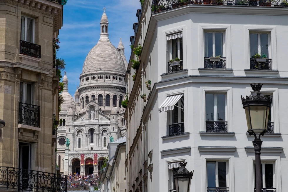 white and brown buildings with windows and blue sky in Paris France