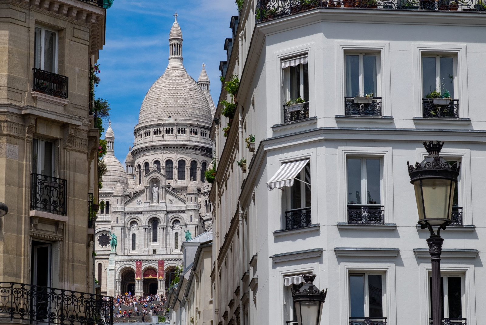 white and brown buildings with windows and blue sky in Paris France