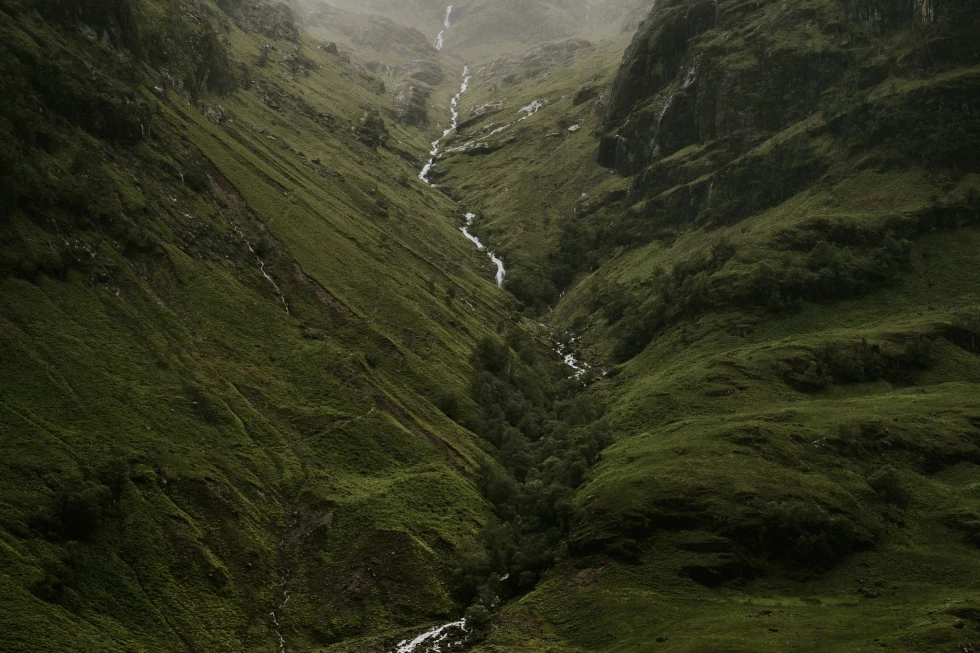 A green highland with a river in the middle. 