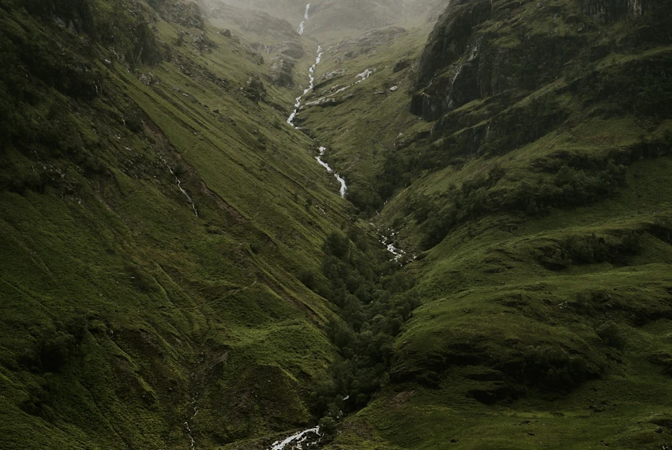 A green highland with a river in the middle.