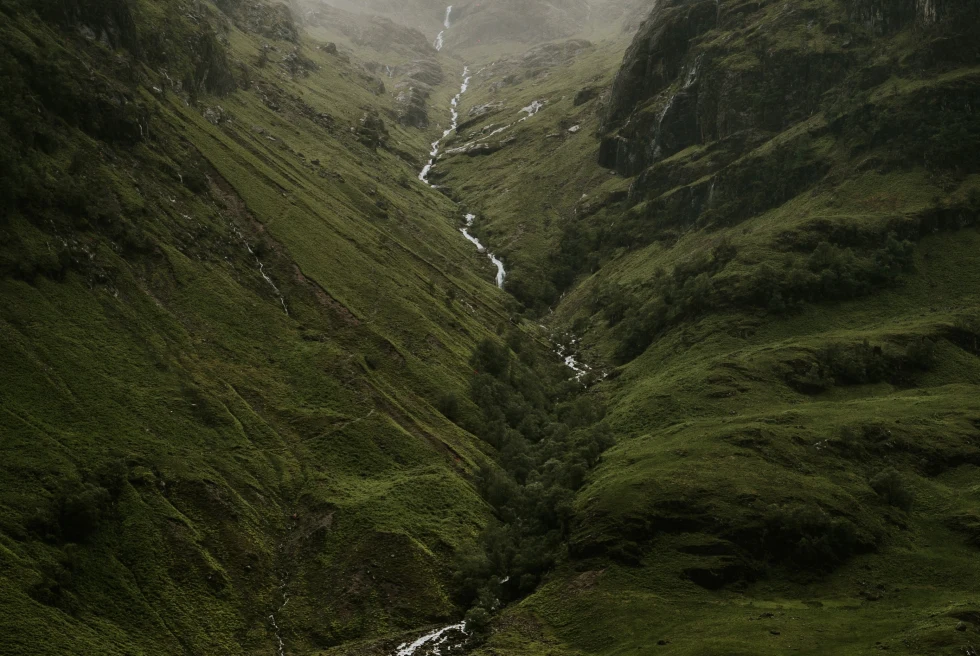 A green highland with a river in the middle. 