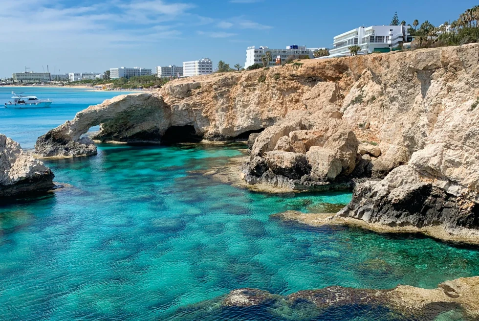 A clear green water with rocky boundary on one side. 