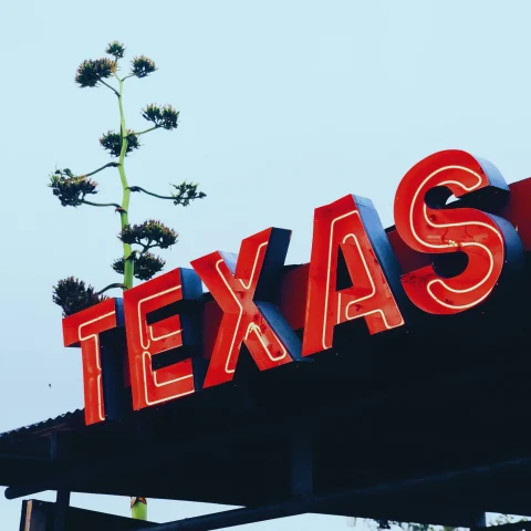 red metal sign that reads "TEXAS"
