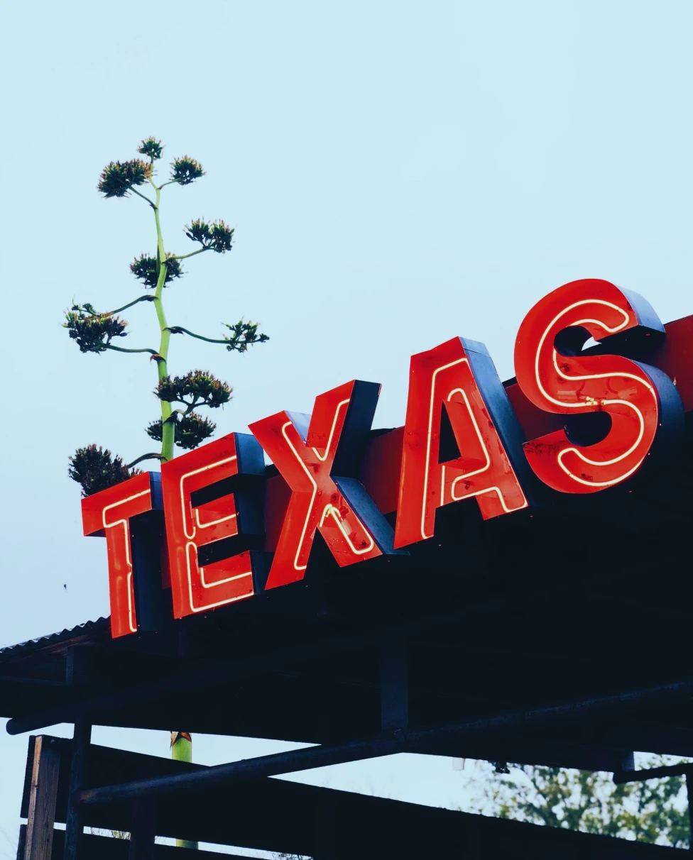 red metal sign that reads "TEXAS"