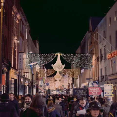 people walking next to buildings with colorful lights