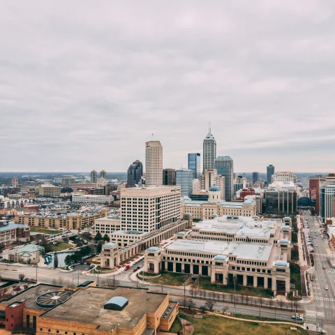 View of buildings and skyscrapers in downtown Indianapolis with a cloudy, grey sky