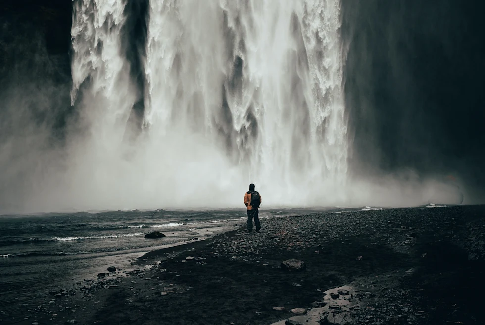 A person standing in front of a waterfall