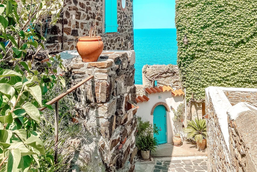 hidden alley way between ivy-covered buildings overlooking the sea