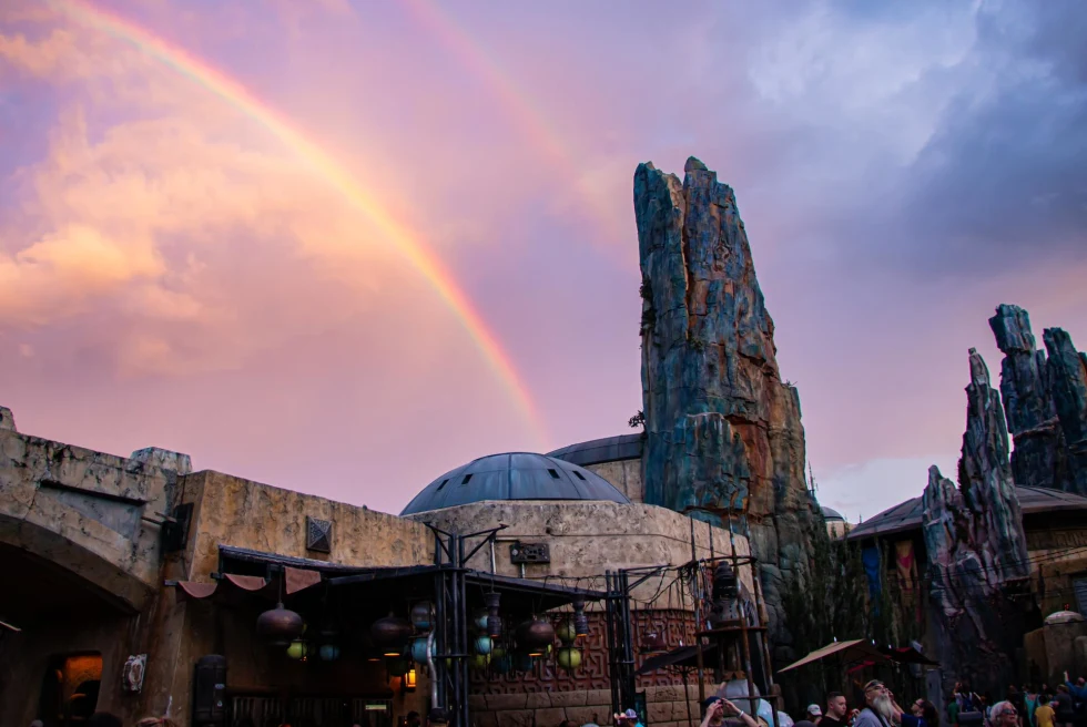 rainbow and pink sky over otherworldly amusement park strcutres