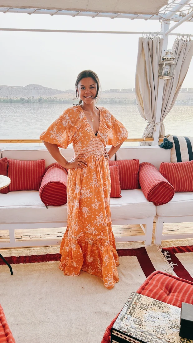 a beautiful woman in an orange floral dress