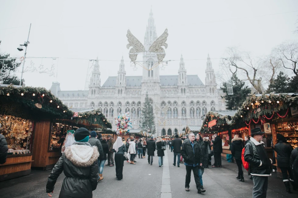  bustling Christmas market during the day with a historic ornate building in the distance