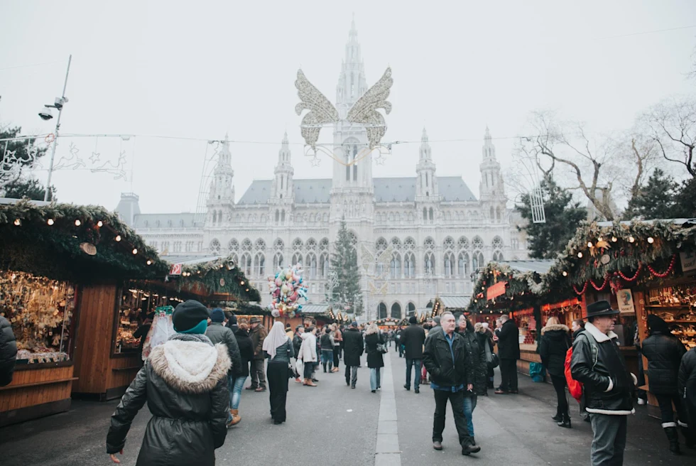 bustling Christmas market during the day with a historic ornate building in the distance