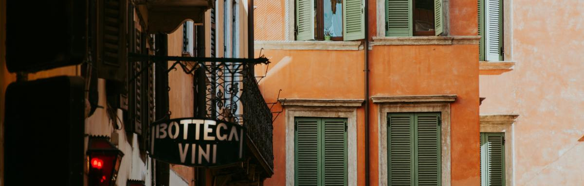 Close up of pastel colored building in a narrow street in Verona, Italy. 
