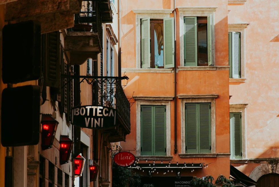 Close up of pastel colored building in a narrow street in Verona, Italy.