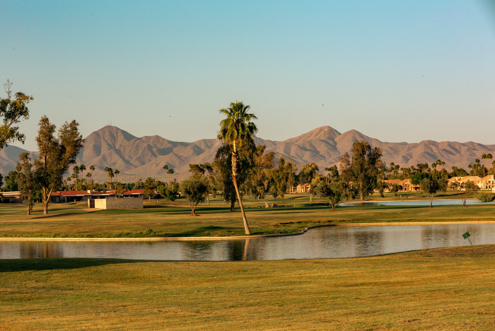 Golf course with a lake and mountains in the background