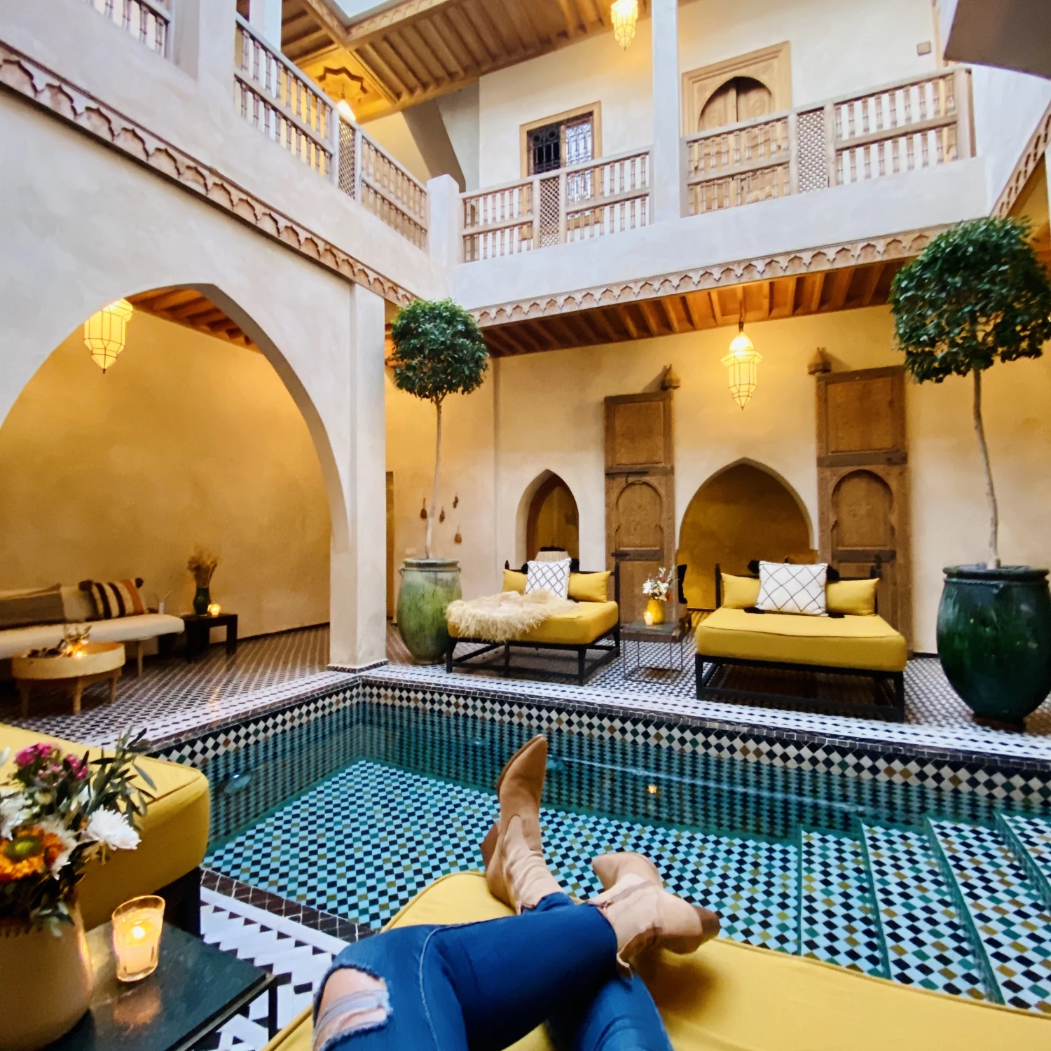 A person chilling in front of an indoor tiled pool.