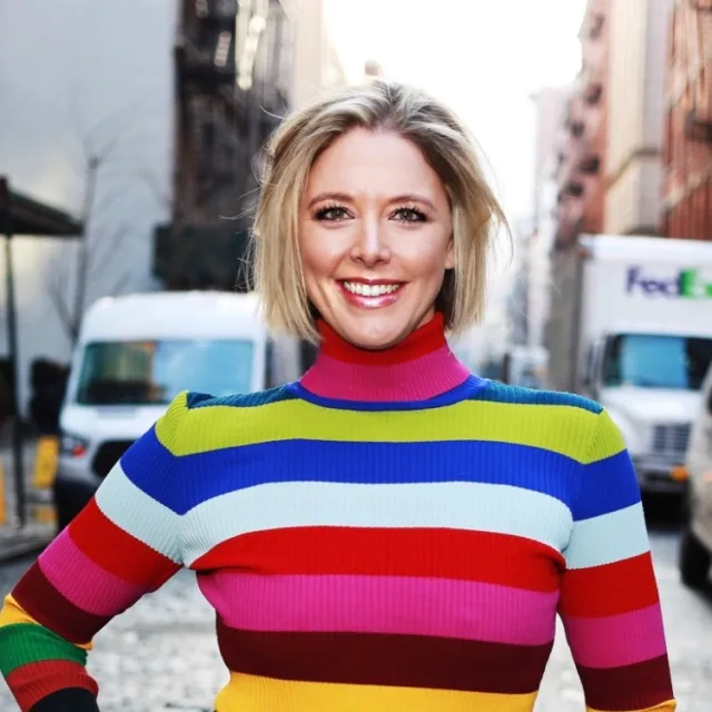Travel advisor Kelly Weber smiles in a colorful striped turtleneck